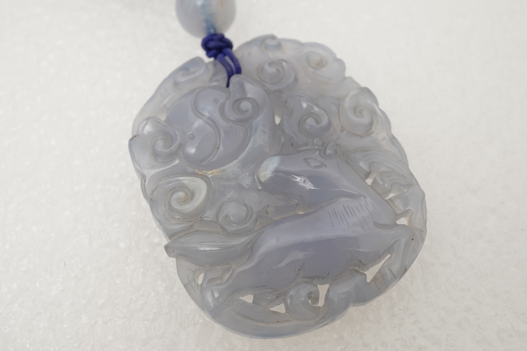 A Chinese jade ‘spirit lock’ plaque, a jadeite bead necklace and a blue quartz bead necklace, 20th century